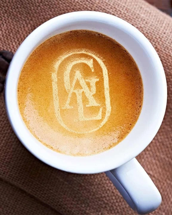 Tasse Kaffee von oben, im Schaum das GÁL-Monogramm